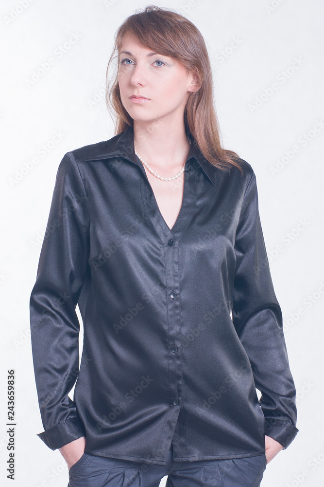 Beautiful young woman in black shirt and trousers on bright background. Fashion studio shoot Beautiful young woman in black shirt and trousers on bright background. Fashion studio shoot