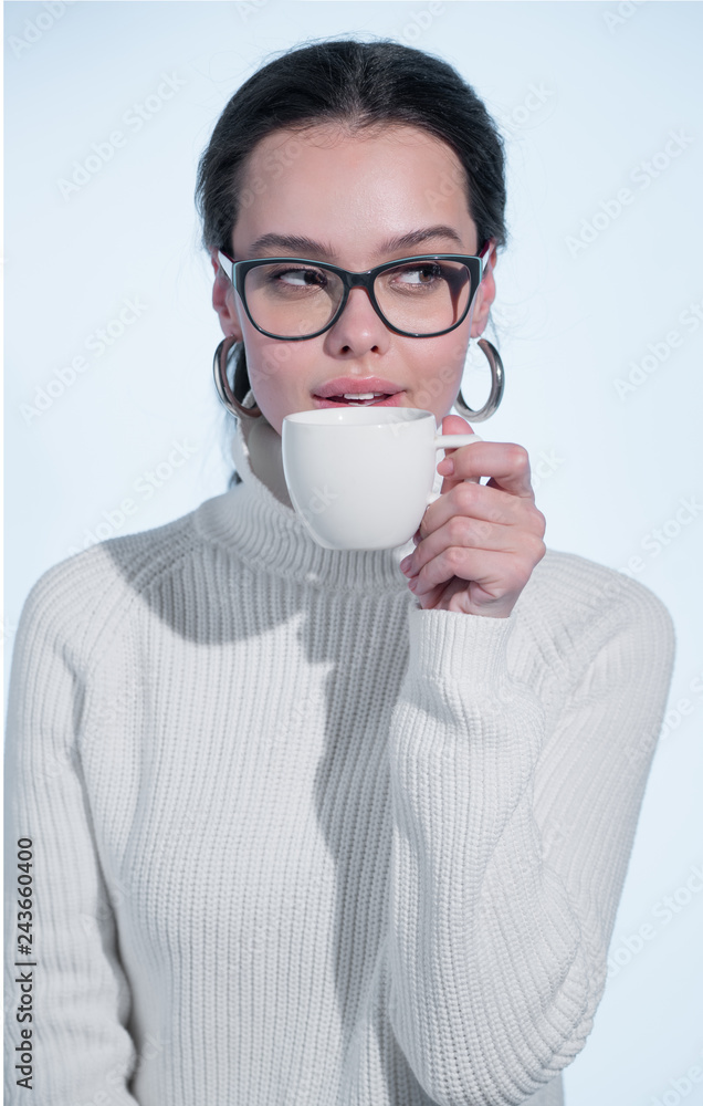 Girl in white sweater drinking coffee and smiling Girl in white sweater drinking coffee and smiling