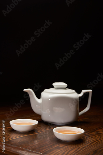 tea pot and cups with traditional chinese tea isolated on black with copy space