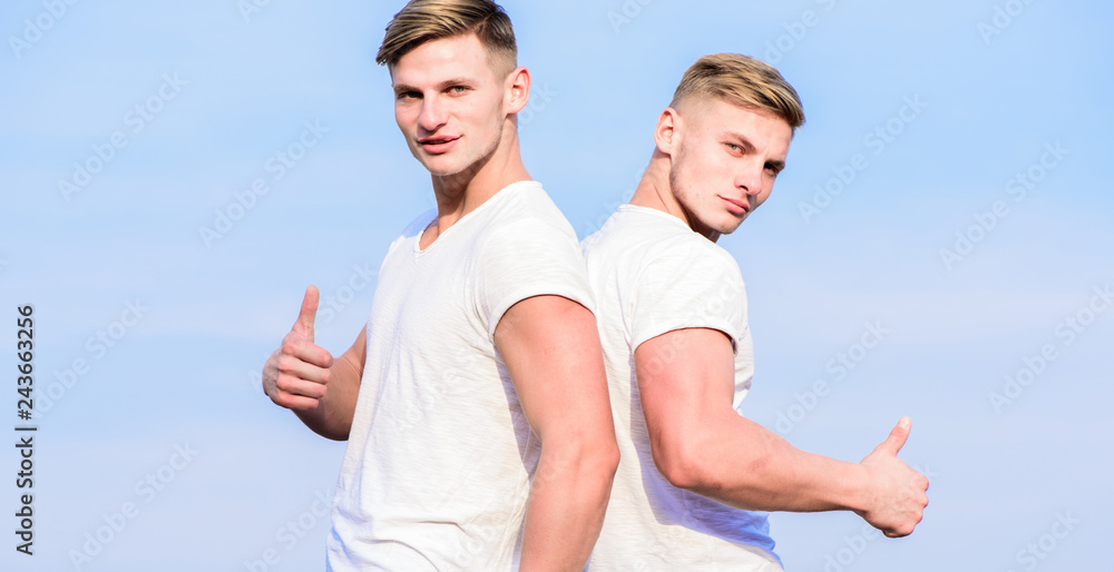 Friendship of brothers. Benefits and drawbacks of having identical twin brother. Men twins brothers muscular guys in white shirts sky background. Brotherhood concept. Benefits of having twin brother