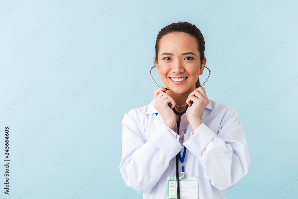 Woman doctor posing isolated over blue wall background with stethoscope. Woman doctor posing isolated over blue wall background with stethoscope.