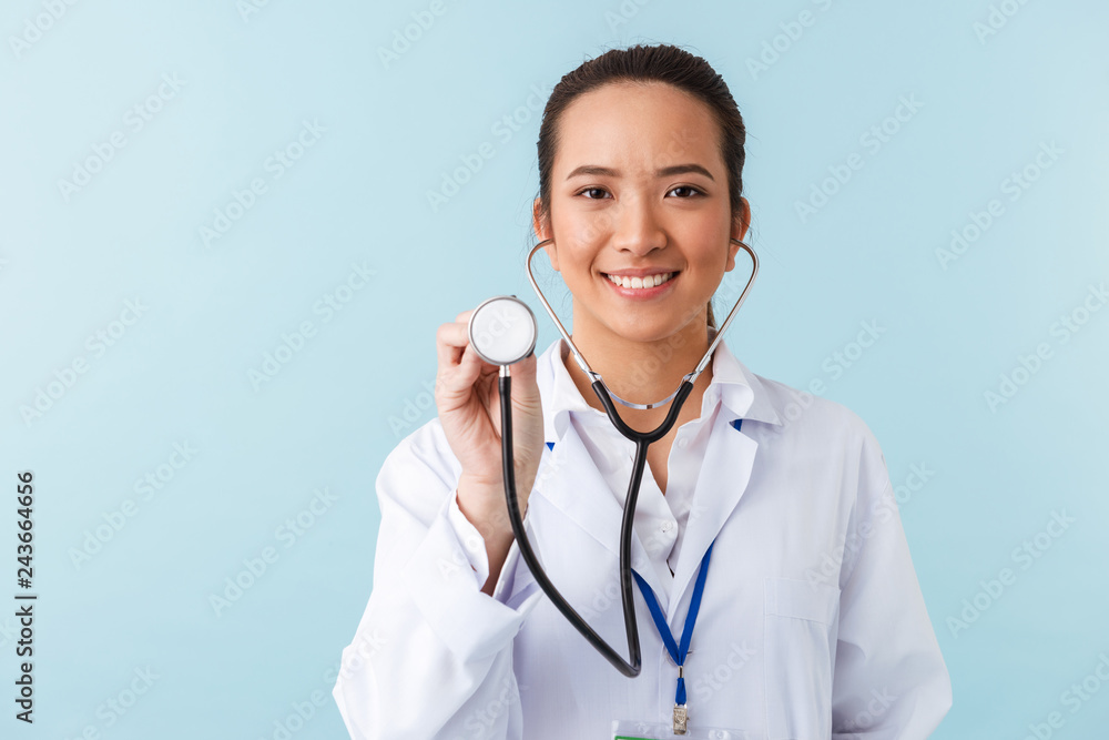 Woman doctor posing isolated over blue wall background with stethoscope. Woman doctor posing isolated over blue wall background with stethoscope.