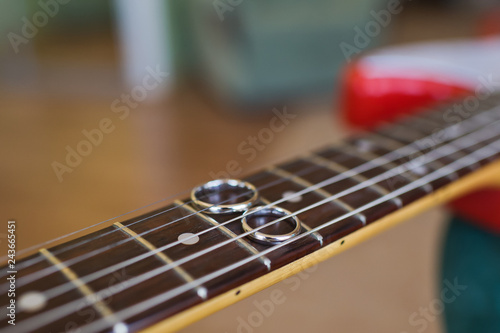 Wedding rings under the strings of the guitar