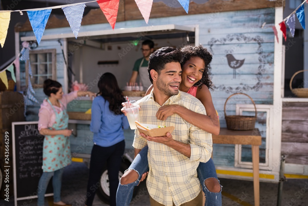 Fototapeta premium Man giving piggy back to woman