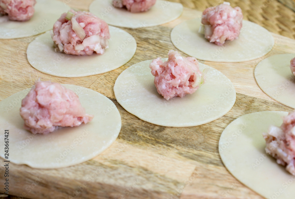 Raw dumplings, minced meat and dough on table