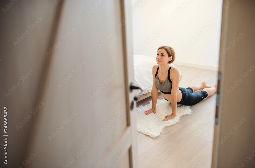 A young woman doing exercise indoors in a bedroom. Copy space. A young woman doing exercise indoors in a bedroom. Copy space.