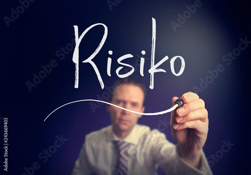 A businessman writing a Risk "Risiko" concept in German with a white pen on a clear screen.