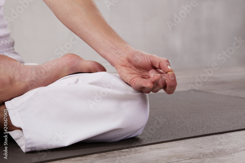 Closeup picture of a man in white clothes practicing yoga © Amelia Fox