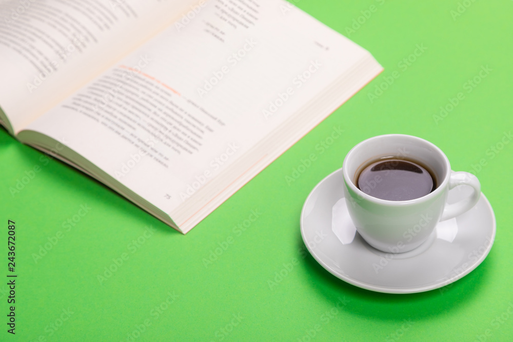 Working table with cup of coffee and book isolated on green background Working table with cup of coffee and book isolated on green background