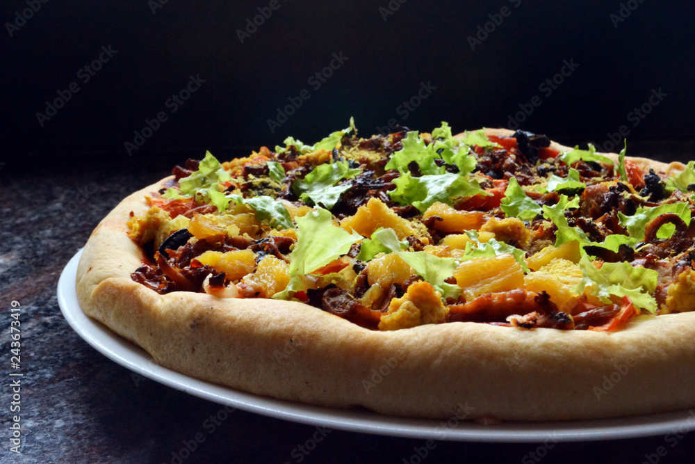 Thick, vegan pizza with tofu cheese, vegan soy sausages, mushrooms, capsicum, black olives, pineapple, tomatoes, lettuce and onions.