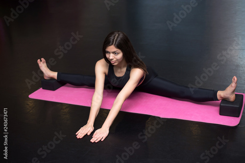 sporty woman is doing a split and stretching