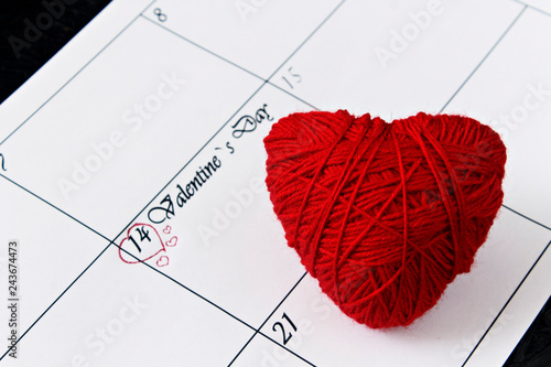 Calendar page with red hearts on February 14, Valentine's Day on a black background. Valentines day greeting card