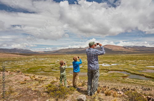Peru, Chivay, Colca Canyon, father and sons taking pictures of swamp landscape in the Andes photo
