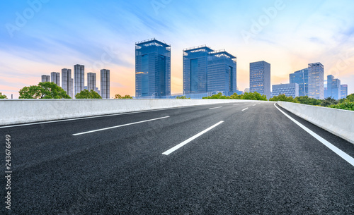 Asphalt road and modern city commercial building in Shanghai at dusk