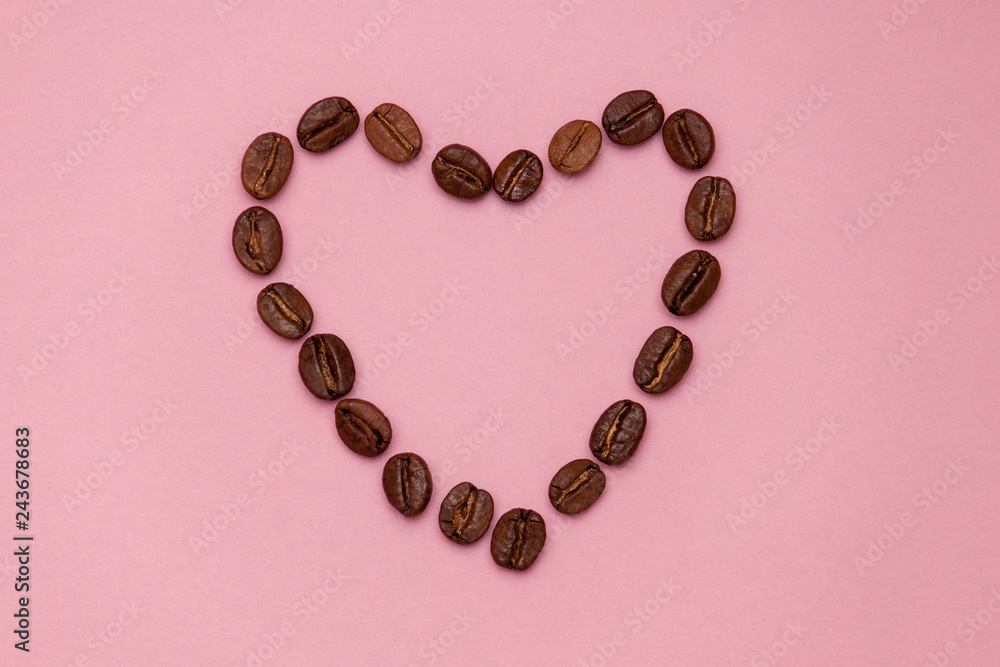 Coffee beans in heart shape on pink background. Copy spase Coffee beans in heart shape on pink background. Copy spase