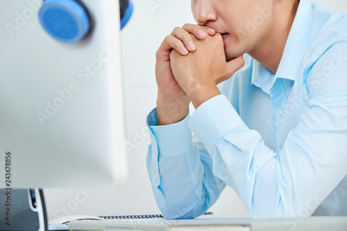 Cropped image of pensive man looking at computer screen and thinking over project