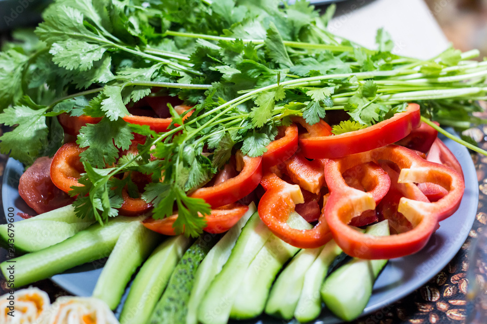 Cut cucumbers and tomatoes pepper parsley on table Cut cucumbers and tomatoes pepper parsley on table