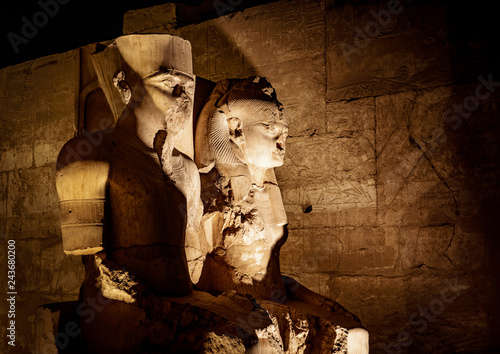 Statue of King Tutankhamen and his Queen at Temple of Luxor in Luxor city (Thebes) in Egypt, illuminated at night
