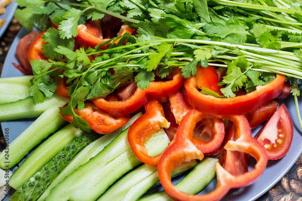Cut cucumbers and tomatoes pepper parsley on table Cut cucumbers and tomatoes pepper parsley on table