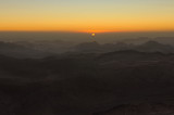 Amazing golden sunrise in the mountains. The sun comes out from the cloud. View from Mount Sinai (Mount Horeb, Gabal Musa, Moses Mount). Sinai Peninsula of Egypt