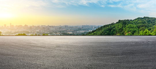 Panoramic city skyline and buildings with empty asphalt road at sunrise