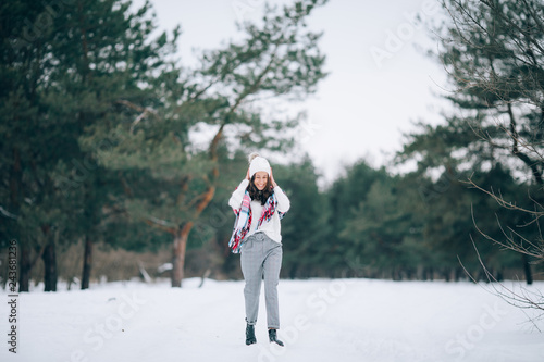 Woman walks and smiles in the winter forest.