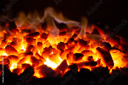 Abstract background of glowing coals in fireplace with fire flames. Burning flame background photo