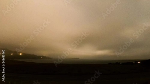 Time lapse of the rare atmospheric phenomena of a lunar rainbow - Moonbow - at night, Staffin Bay on the Isle of Skye, Scotland photo