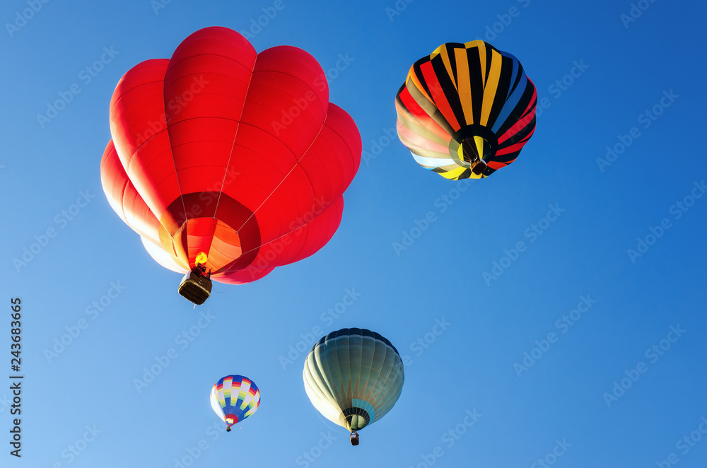 hot-air balloons flying in the blue clear sky just after the take off