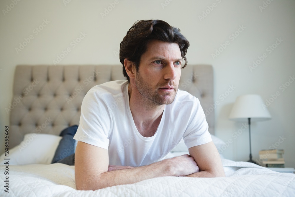 Man relaxing on bed in bedroom at home Man relaxing on bed in bedroom at home