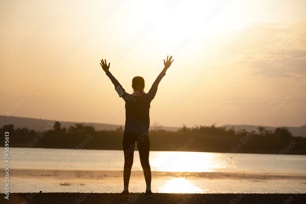 Silhouette of woman with open hand with sunset or sunrise background,