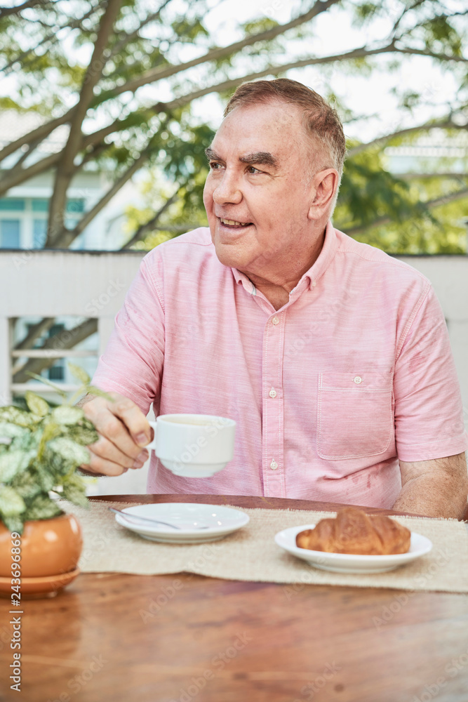 Smiling old man drinking cup of cappuccino in outdoor cafe Smiling old man drinking cup of cappuccino in outdoor cafe