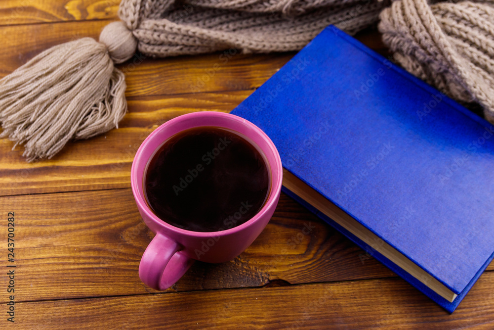 Cup of coffee, knitted scarf and book on wooden background Cup of coffee, knitted scarf and book on wooden background