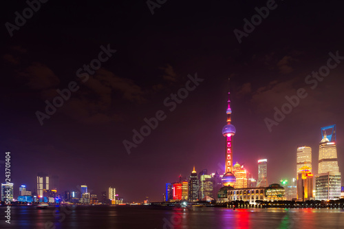 Modern city skyscrapers of Shanghai skyline at night with reflection of beautiful ligth in Huangpu river view from the bund, Shanghai, China © lukyeee_nuttawut