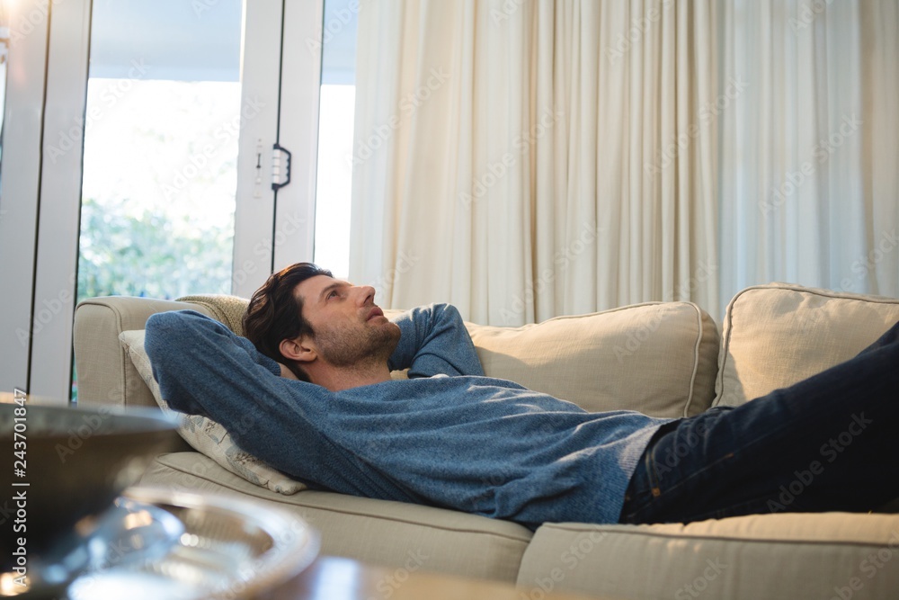 © WavebreakMediaMicro - Man relaxing on sofa in living room