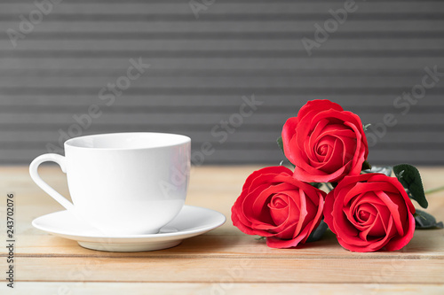 Red rose and coffee cup on wood