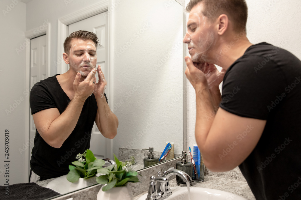 Good Looking Young Man Washing Hands and Face in Home Bathroom Mirror and Sink Getting Clean and Groomed During Morning Routine Good Looking Young Man Washing Hands and Face in Home Bathroom Mirror and Sink Getting Clean and Groomed During Morning Routine