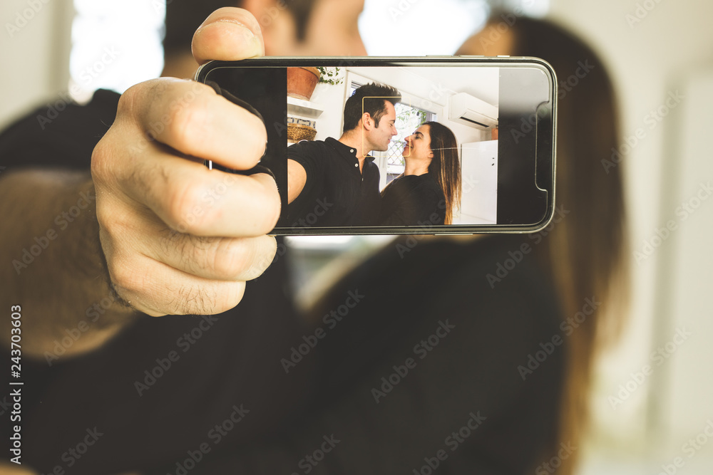 Couple making a selfi kissing and smiling. Love and romance between man and woman