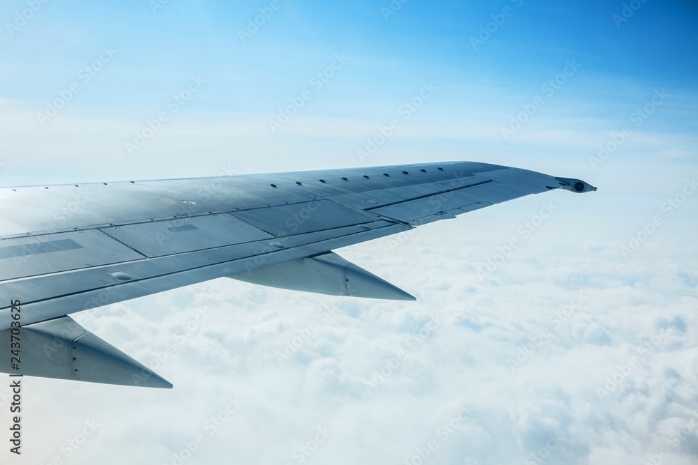 Airplane Wing Out of Window with Clouds and Sky Airplane Wing Out of Window with Clouds and Sky