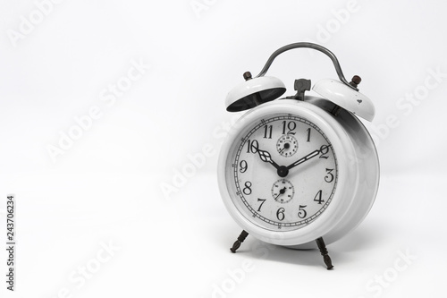 old white analog twin bell alarm clock isolated on a white background. Vintage metal object, ruined by time. Wake up early in the morning to the sound of the bell.