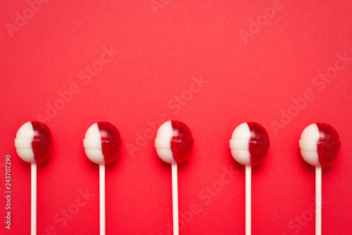 Lollipop on a red background. Space for text or design. © Nikolay