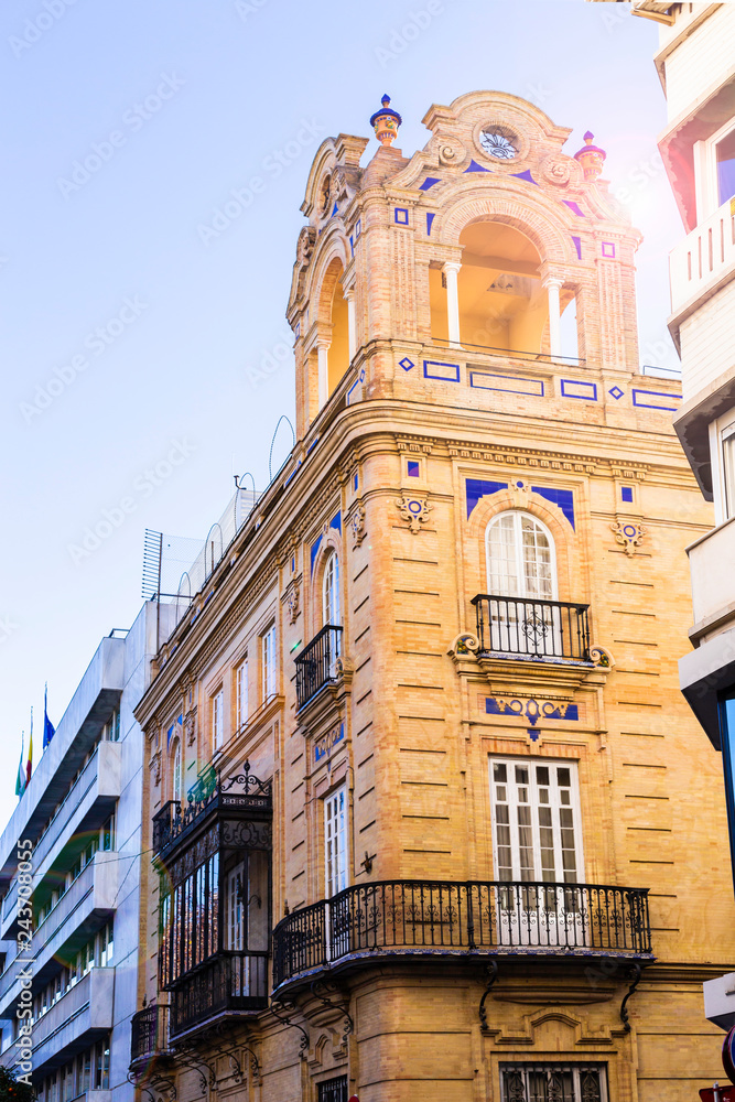 Obraz premium Traditional facades of houses with twisted forged balconies of the city of Seville, Andalusia Spain