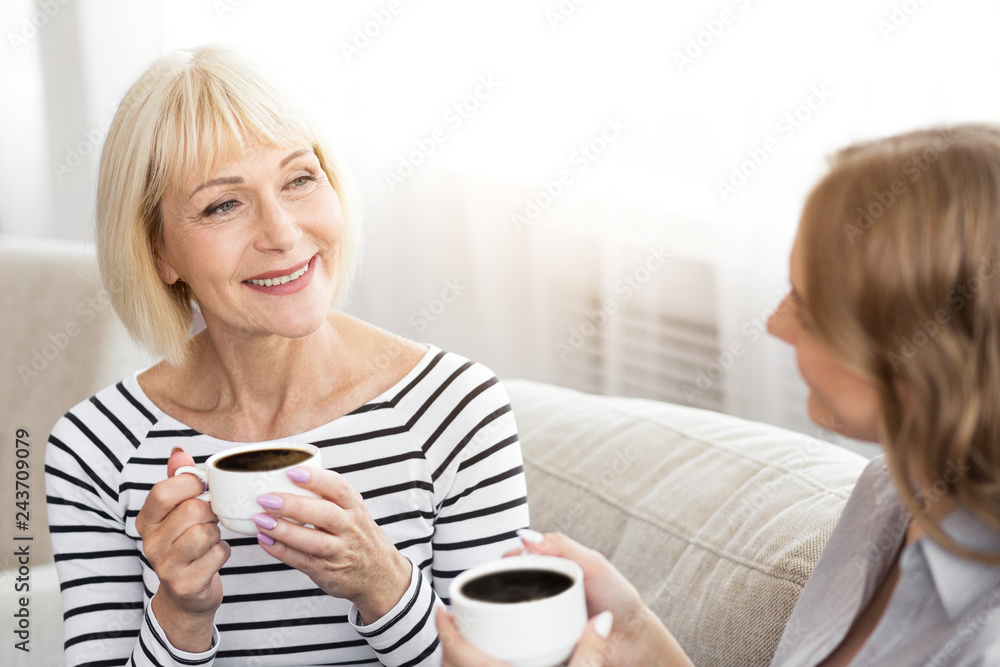 Mature mother and her daughter drinking coffee Mature mother and her daughter drinking coffee