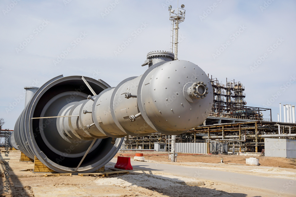 Part of the technological column at the refinery for the production of light oil products on the background of the installation. Manhole for penetration inside. Part of the technological column at the refinery for the production of light oil products on the background of the installation. Manhole for penetration inside.