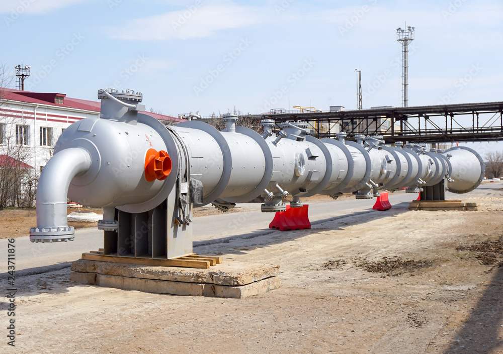 Part of the technological column at the refinery for the production of light oil products on the background of the installation. Manhole for penetration inside. Part of the technological column at the refinery for the production of light oil products on the background of the installation. Manhole for penetration inside.