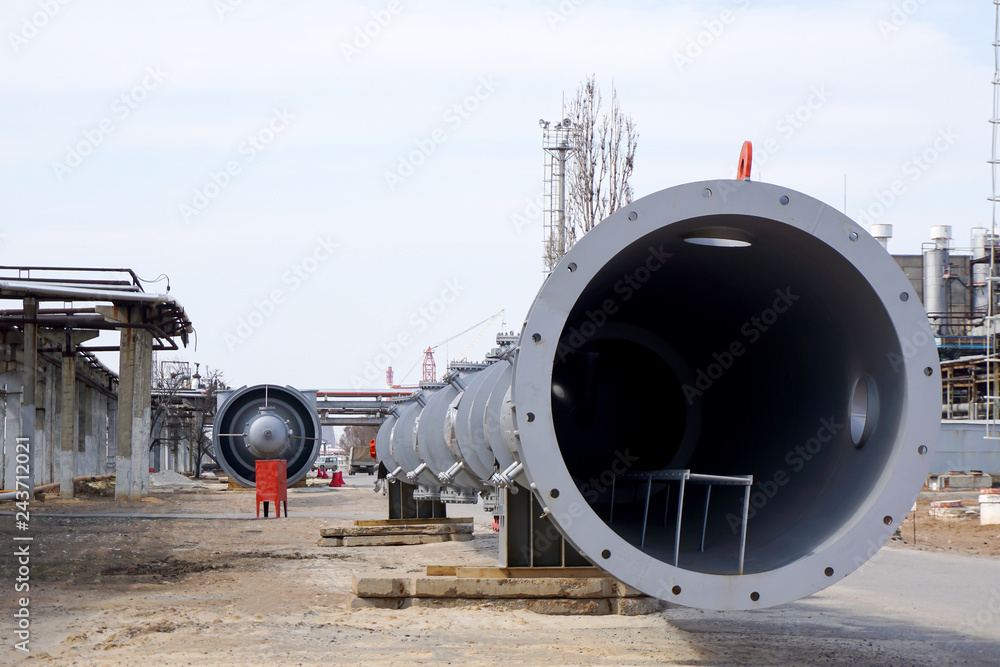 Part of the technological column at the refinery for the production of light oil products on the background of the installation. Manhole for penetration inside. Part of the technological column at the refinery for the production of light oil products on the background of the installation. Manhole for penetration inside.