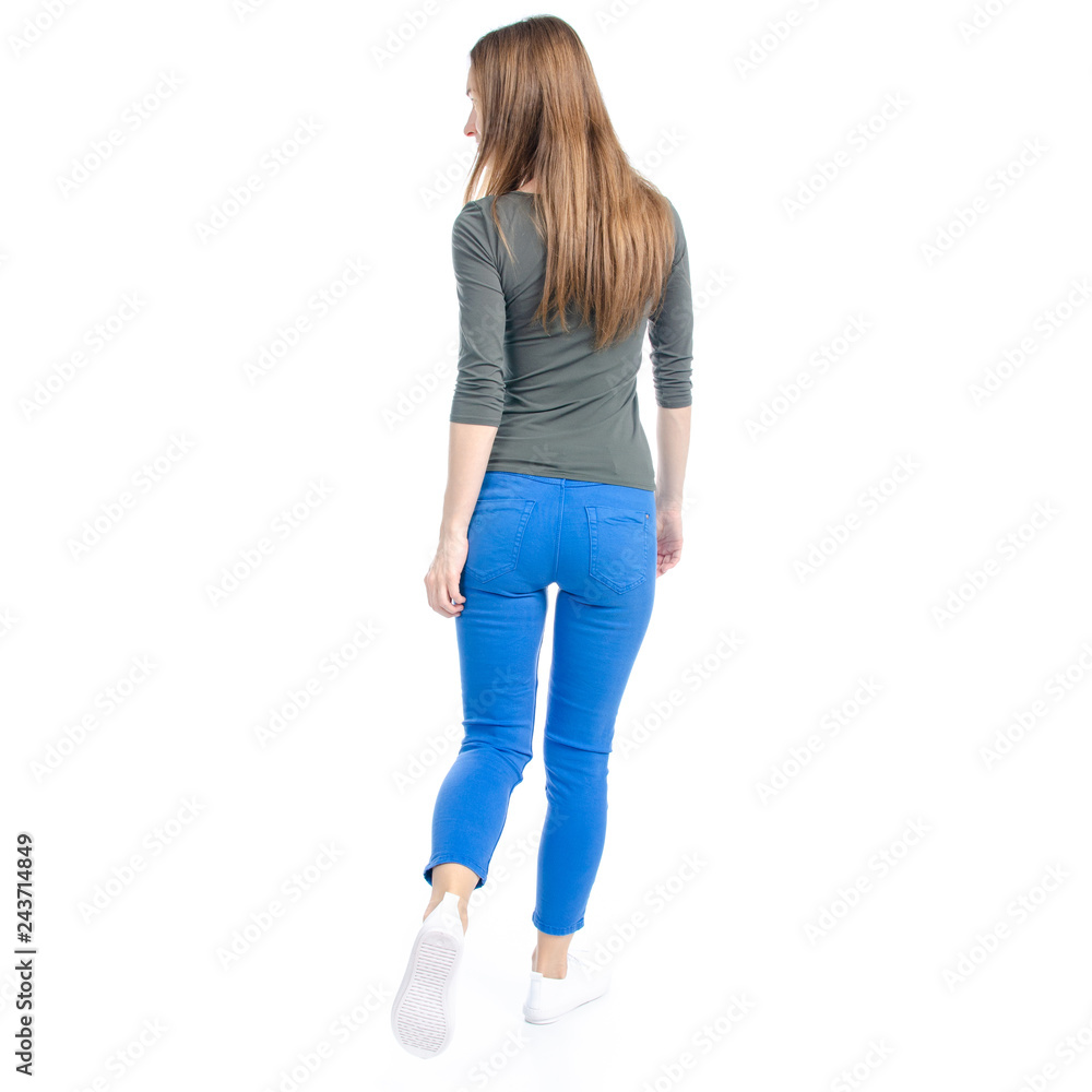 Obraz premium Woman in jeans and white sneakers goes on white background isolation, back view