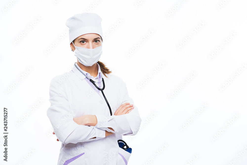 Portrait of an amiable young attractive female doctor, nurse, medical specialist in mask and white uniform.