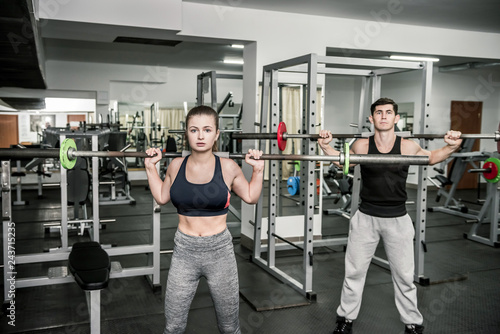 Pair training instructor with woman, both holding dumbbells