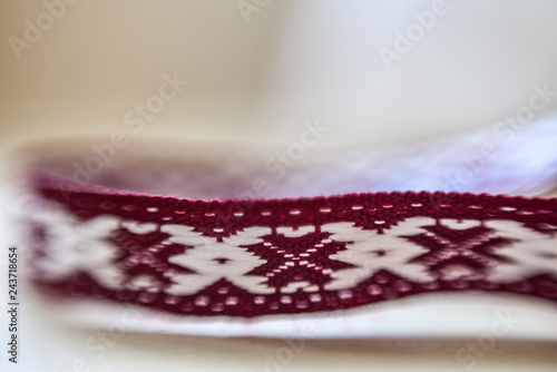 Latvian ornament belt on white blurred background. Selective focus. Macro